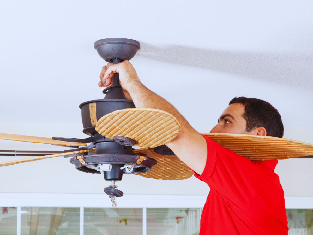 Electrician ensuring proper placement during ceiling fan install