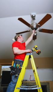 Electrician installing ceiling fan where light fixture use to be
